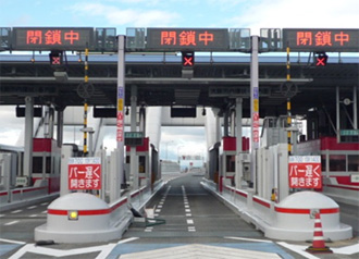 画像:ETCガントリーに「バーが遅く開きます」の注意喚起看板を試行的に設置